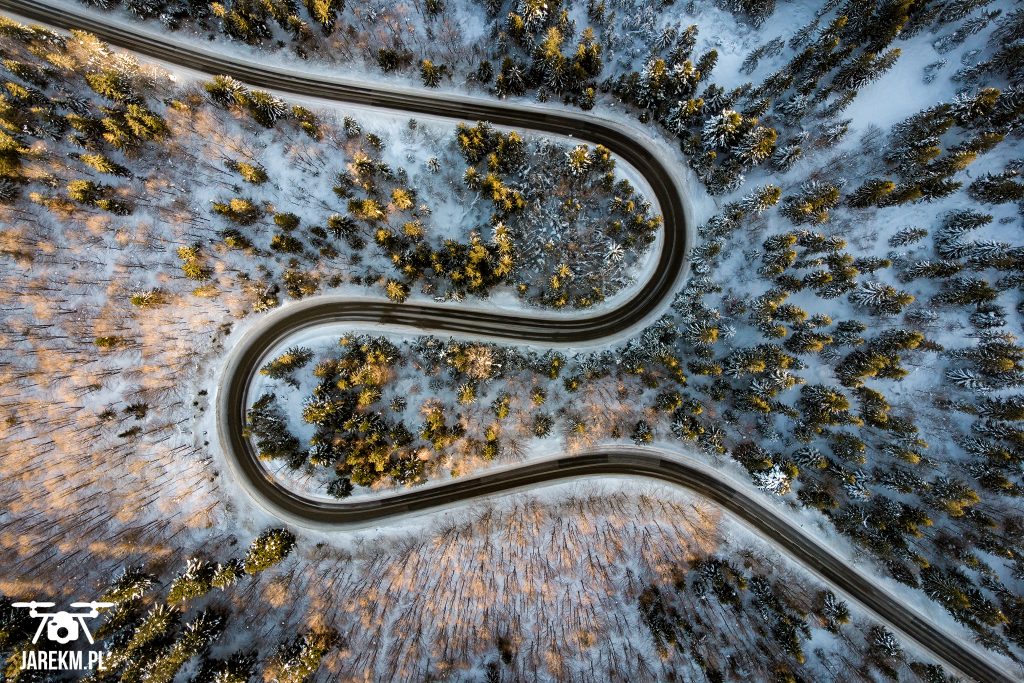Zdjęcie z drona krętej drogi w lesie.